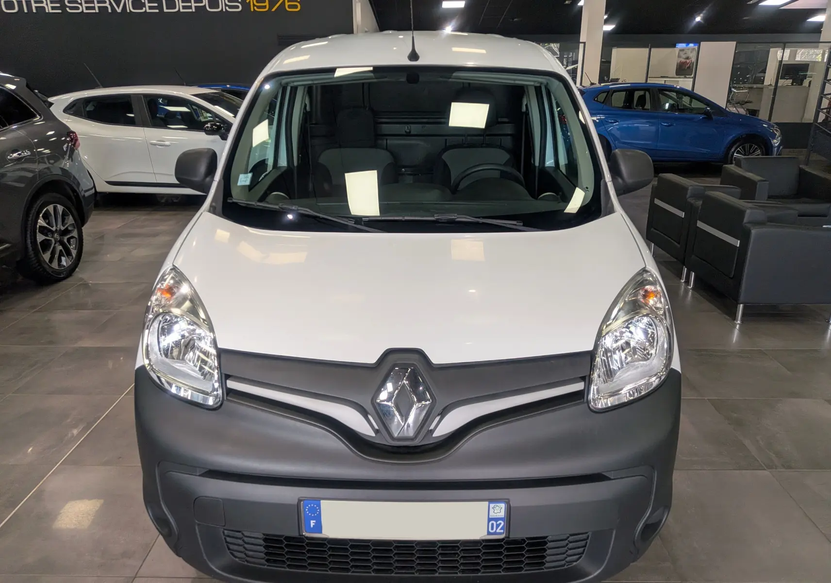 Vue de face d'un Renault Kangoo Express blanc minéral 2020 avec pare-chocs noirs et logo Renault bien visible.