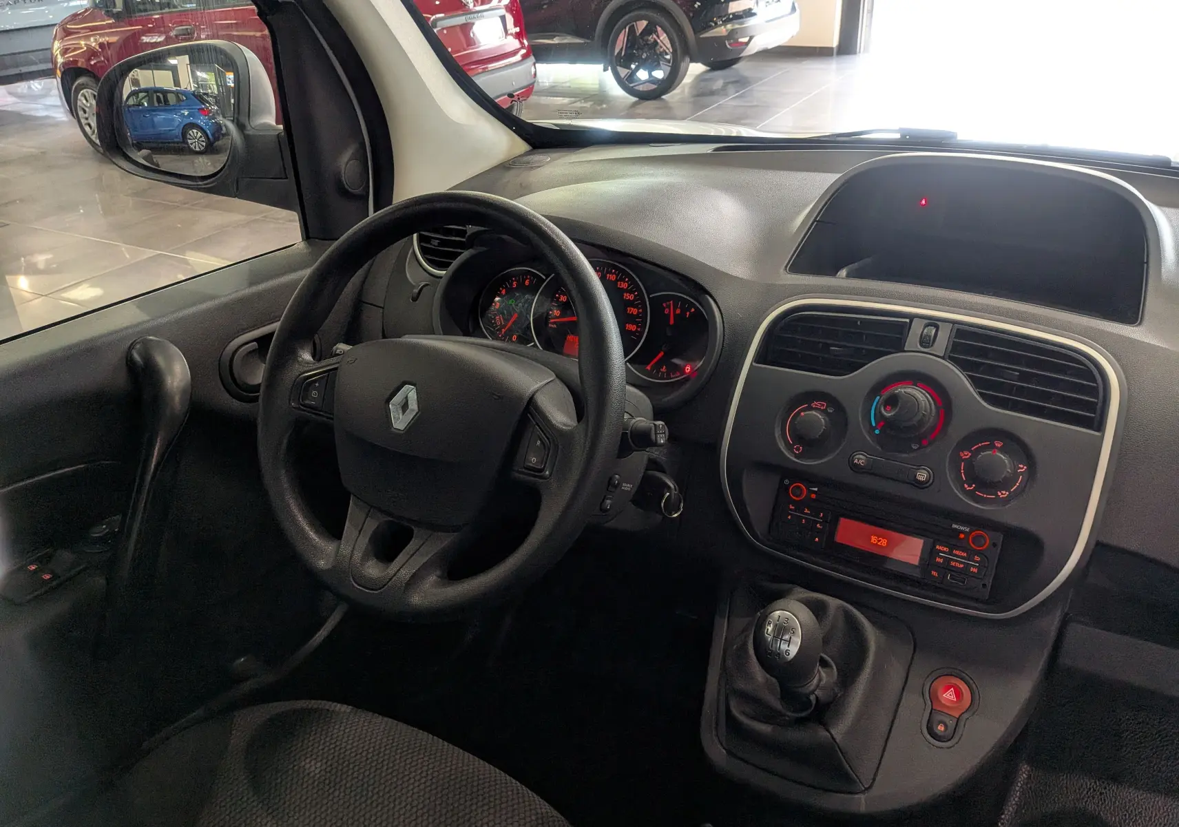 Vue intérieure du tableau de bord et volant du Renault Kangoo Express 2020 avec boîte manuelle et commandes de climatisation visibles.