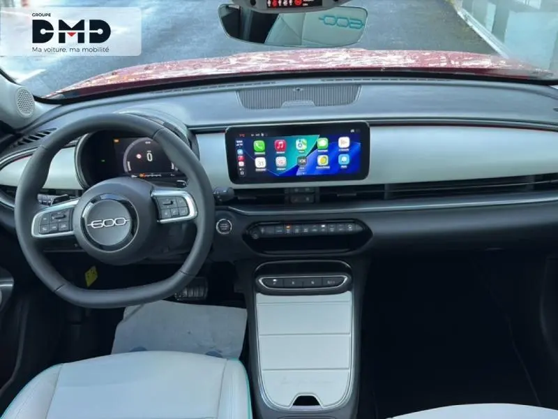 Vue intérieure frontale du tableau de bord gris clair et noir du FIAT 600 hybride avec écran tactile central et volant multifonction.