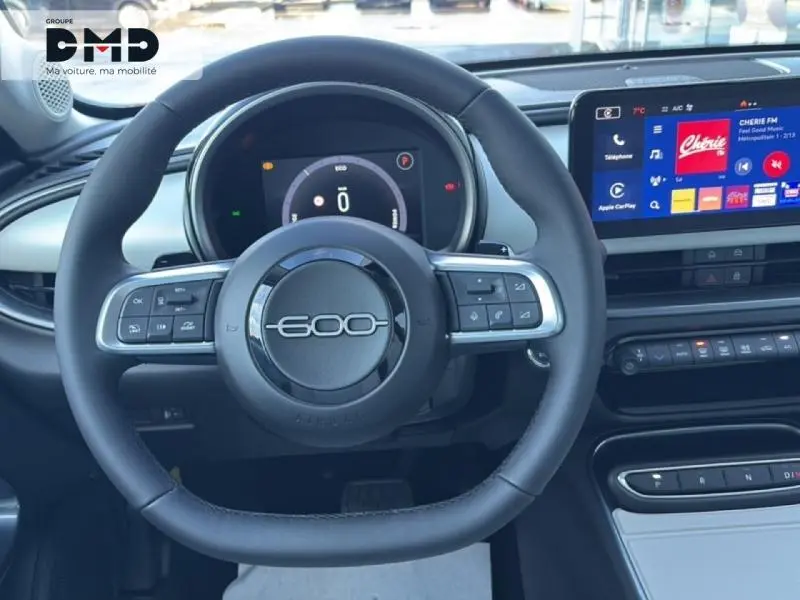 Vue frontale du volant noir marqué 600 et du tableau de bord numérique avec écran tactile du Fiat 600 hybride rouge 2026.