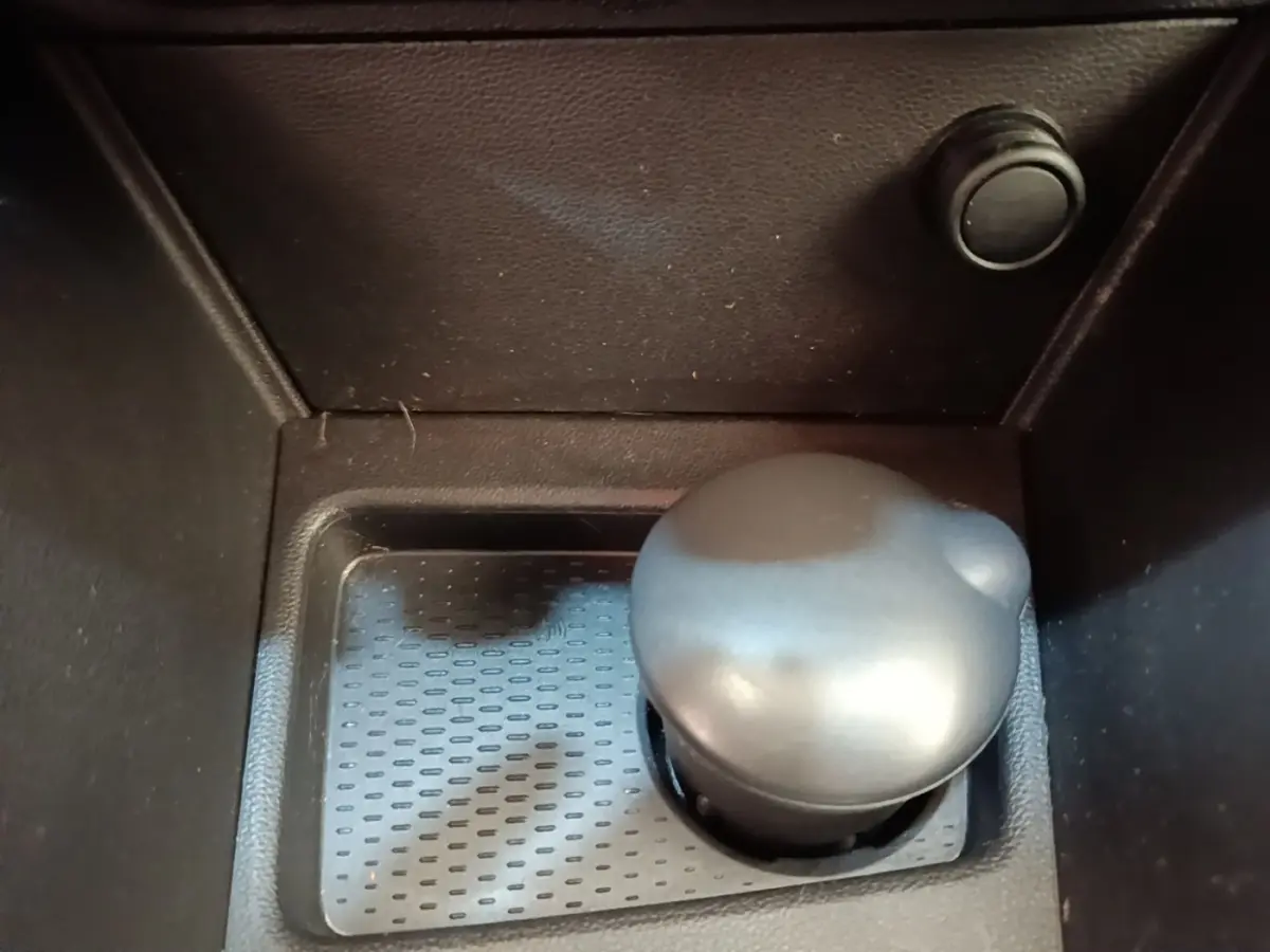 Gros plan sur le levier de vitesses manuel noir du Dacia Duster Confort Blue dCi 115 4x4, intérieur sombre.
