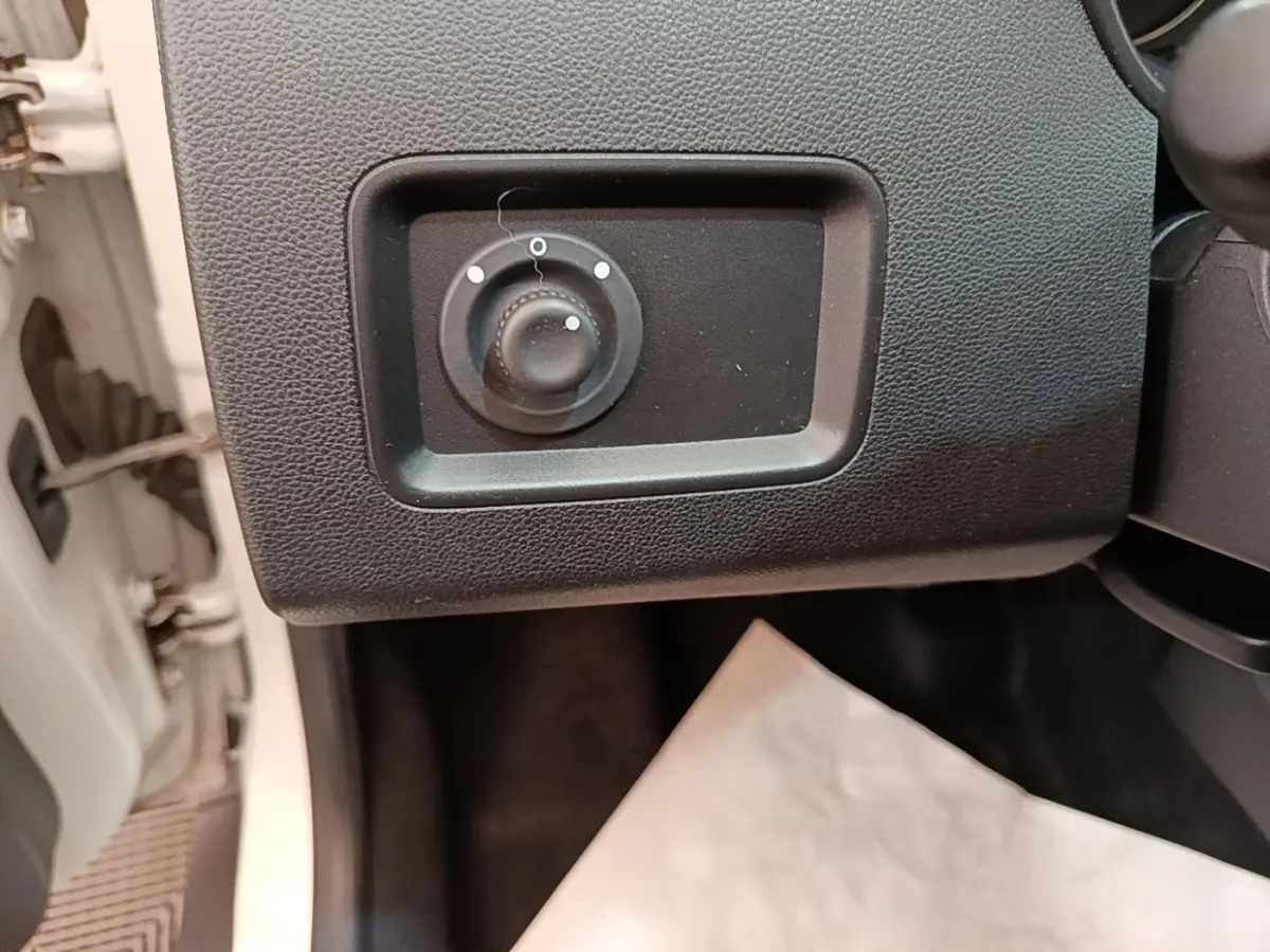 Détail du réglage des rétroviseurs côté conducteur du Dacia Duster blanc, intérieur côté gauche.