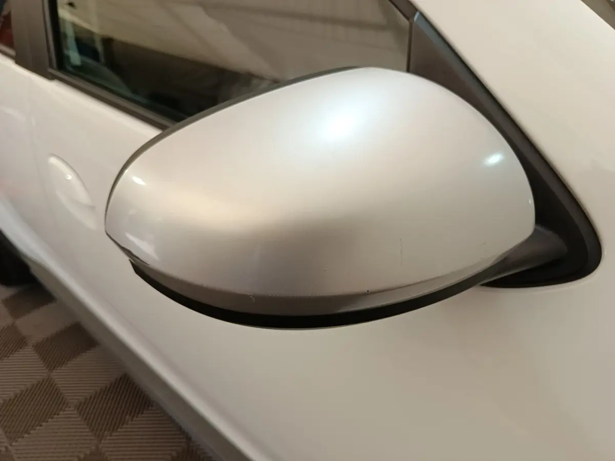 Gros plan sur le rétroviseur droit blanc du Dacia Duster Confort Blue dCi 115 4x4 de 2021.