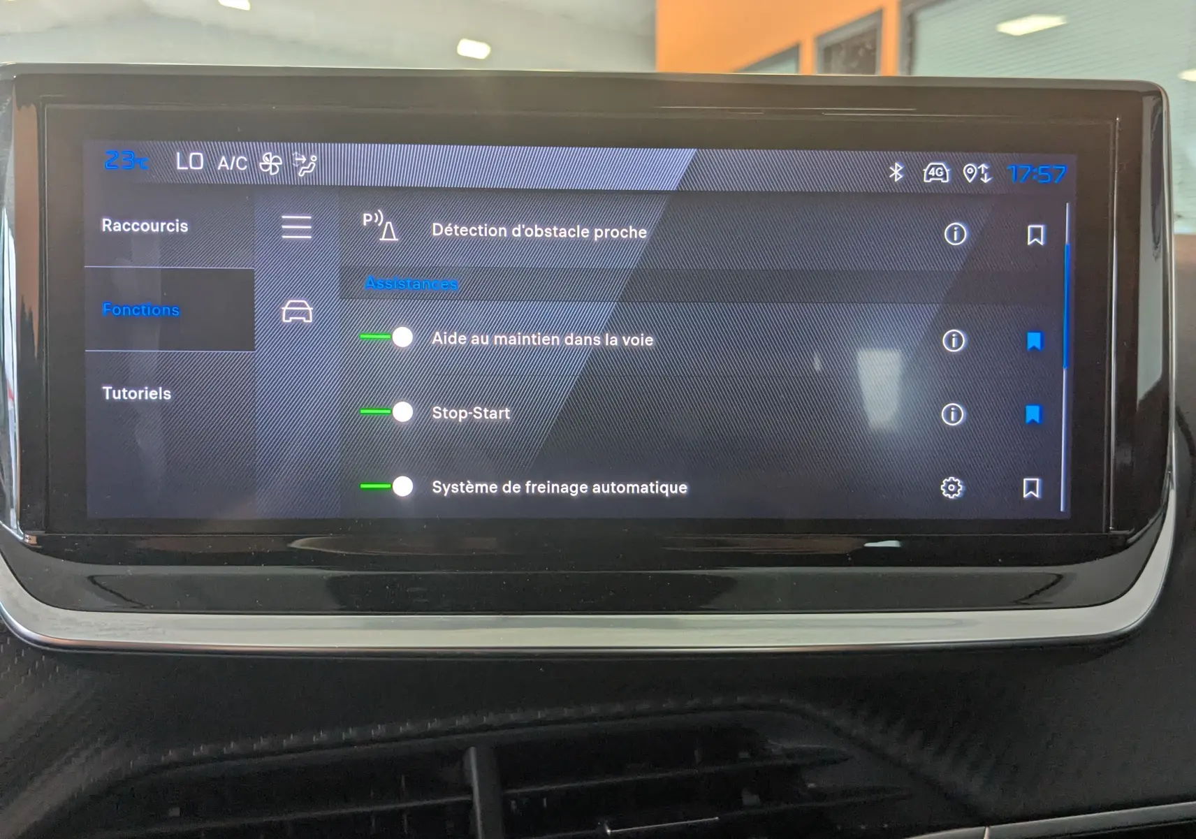 Écran tactile central du Peugeot 2008 Hybrid 145 Allure affichant les assistances à la conduite, intérieur gris noir.