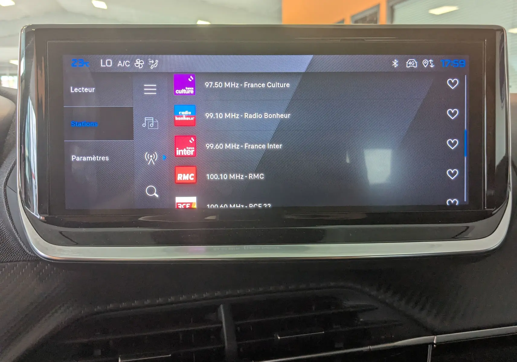 Écran tactile central de la Peugeot 2008 Hybrid 145 en affichage radio, intérieur noir avec détails chromés.