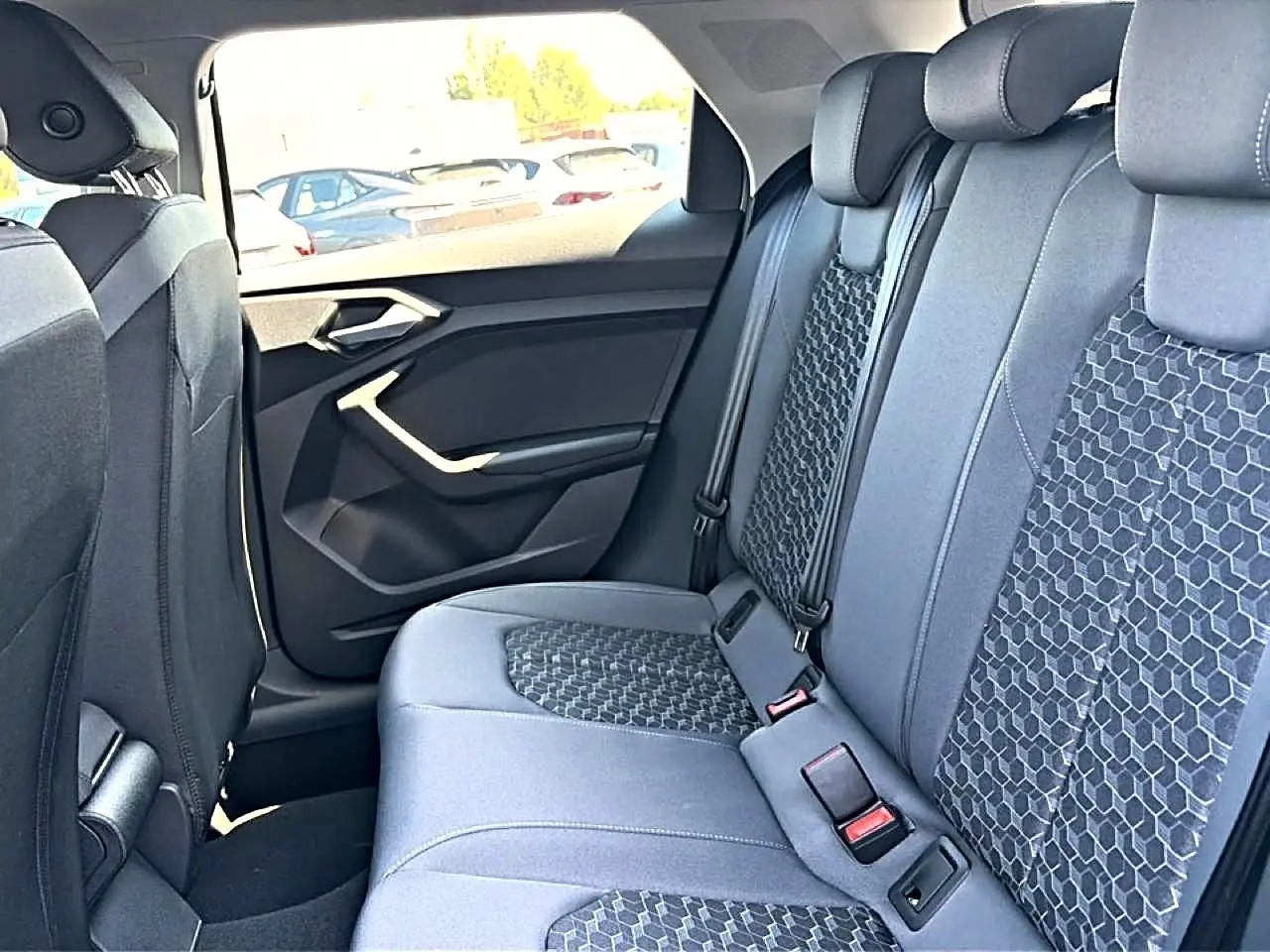 Vue intérieure côté droit des sièges arrière gris foncé avec motifs géométriques d'une Audi A1 Sportback 2026.