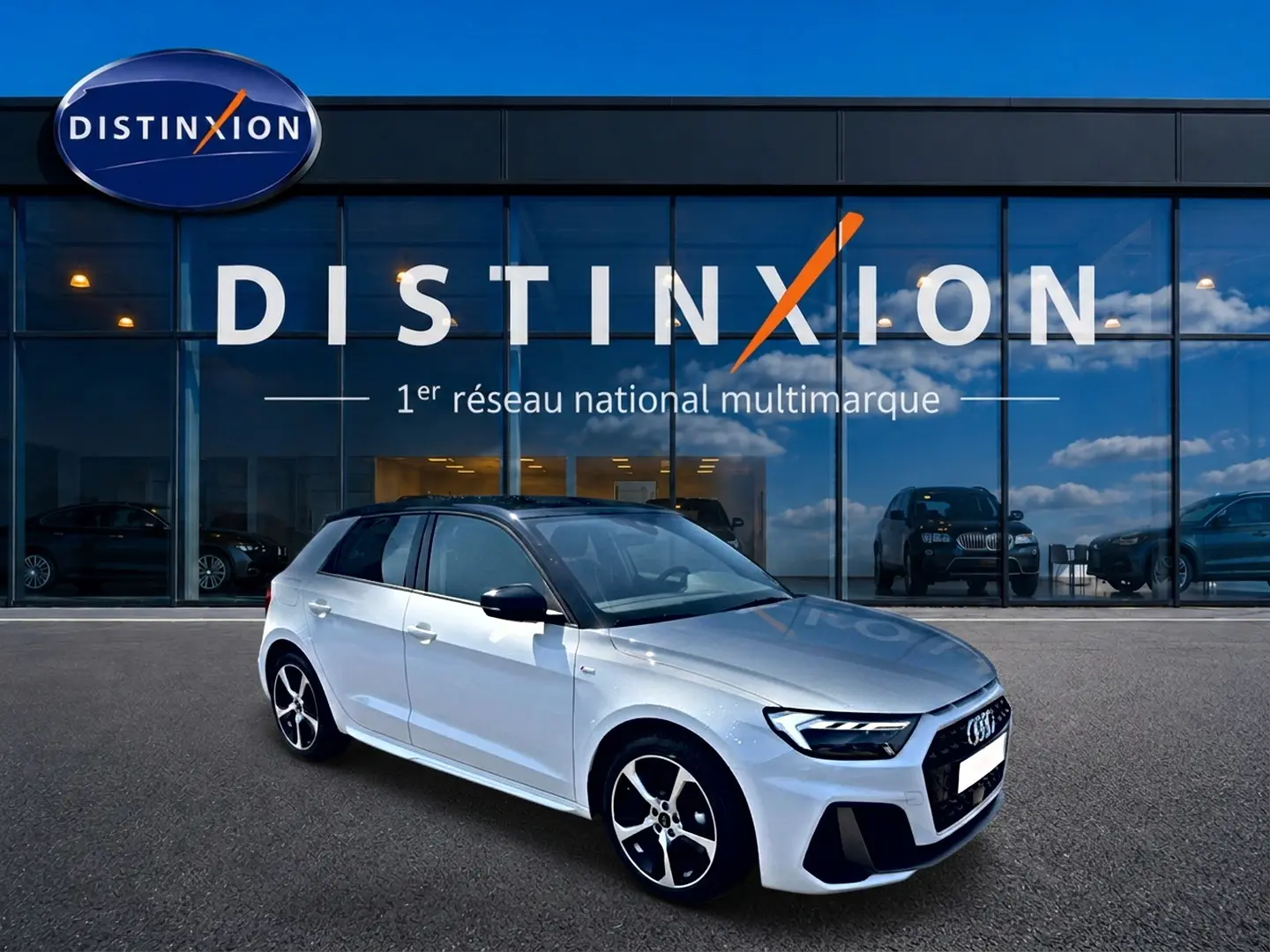 Audi A1 Sportback blanc et noir vue 3/4 avant droit devant un showroom Distinxion avec jantes alu distinctives.