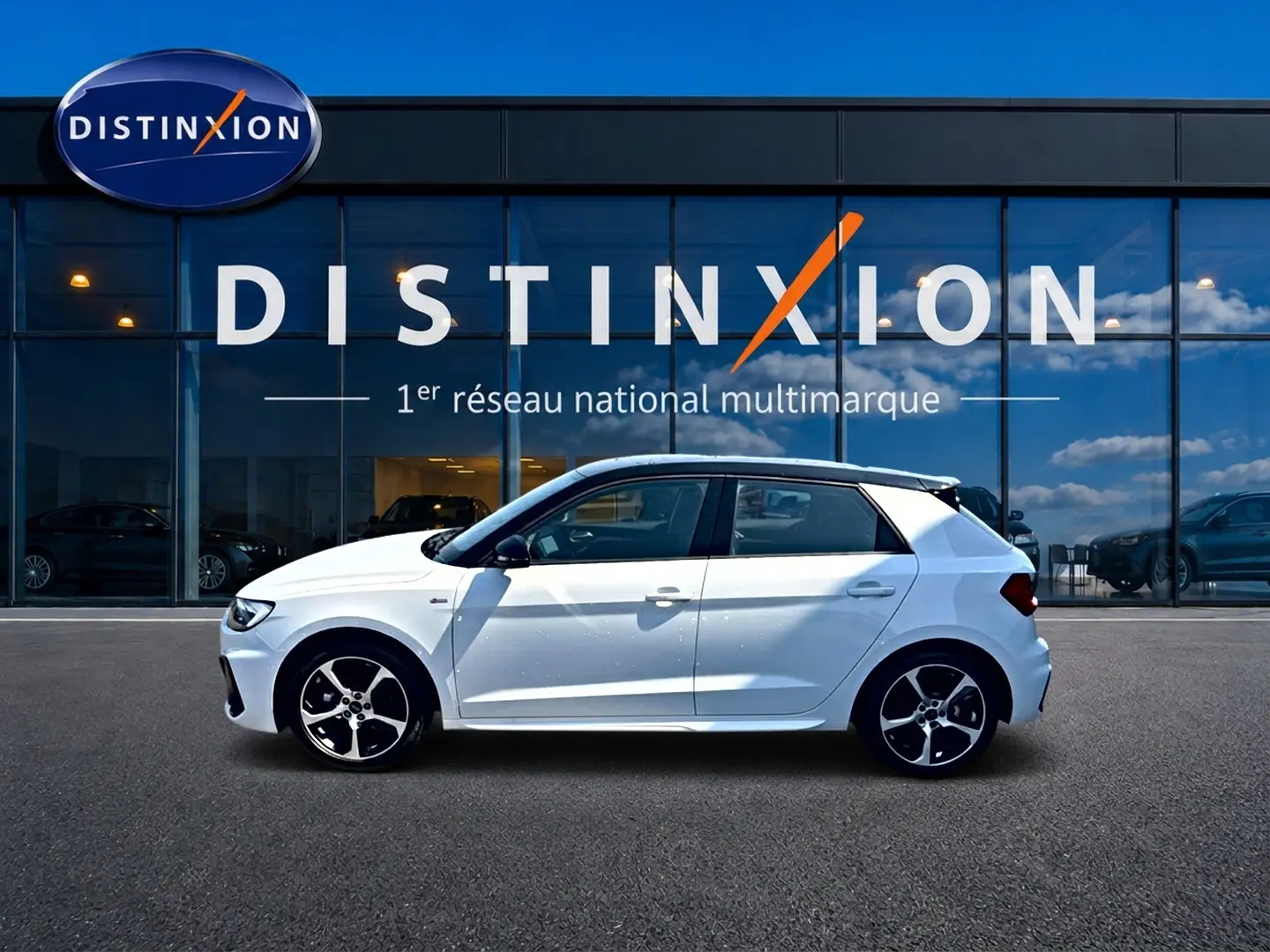 Audi A1 Sportback blanc et noir vue de profil côté gauche devant une vitrine avec logo Distinxion.