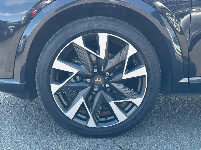 Gros plan sur la roue avant droite d’une CUPRA Formentor Noir Minuit métallisé avec jante alliage noire et argentée au design anguleux.