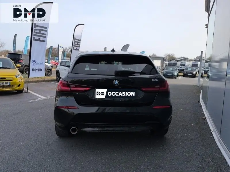 Vue arrière d'une BMW Série 1 118iA noire métallisée, avec feux LED et sortie d'échappement chromée visible.