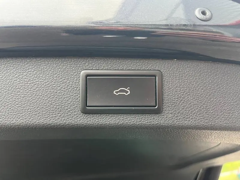 Bouton d'ouverture électrique du coffre sur la garniture intérieure noire du hayon d'un Skoda Kodiaq noir Magic Nacré.