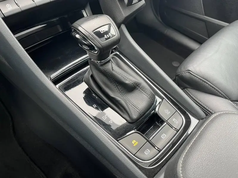 Gros plan sur le levier de vitesses automatique noir cuir du Skoda Kodiaq 2.0 TDI, avec commandes 4x4 et assistance.