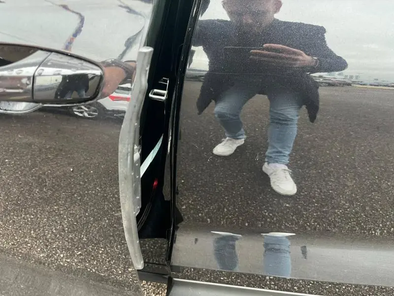 Détail de la portière ouverte côté gauche d’un Skoda Kodiaq noir Magic Nacré avec reflet au sol et sur la carrosserie.