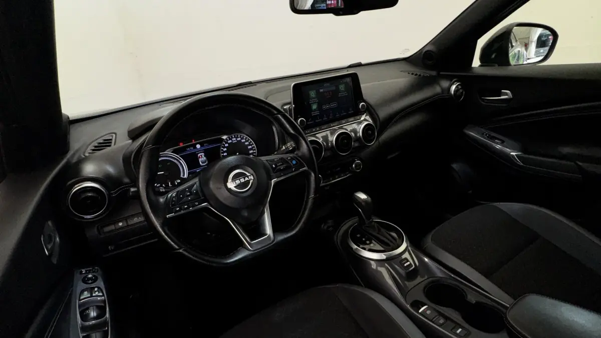 Vue intérieure côté conducteur du Nissan Juke Hybrid 143 Business+ 2023, tableau de bord noir avec écran tactile central.