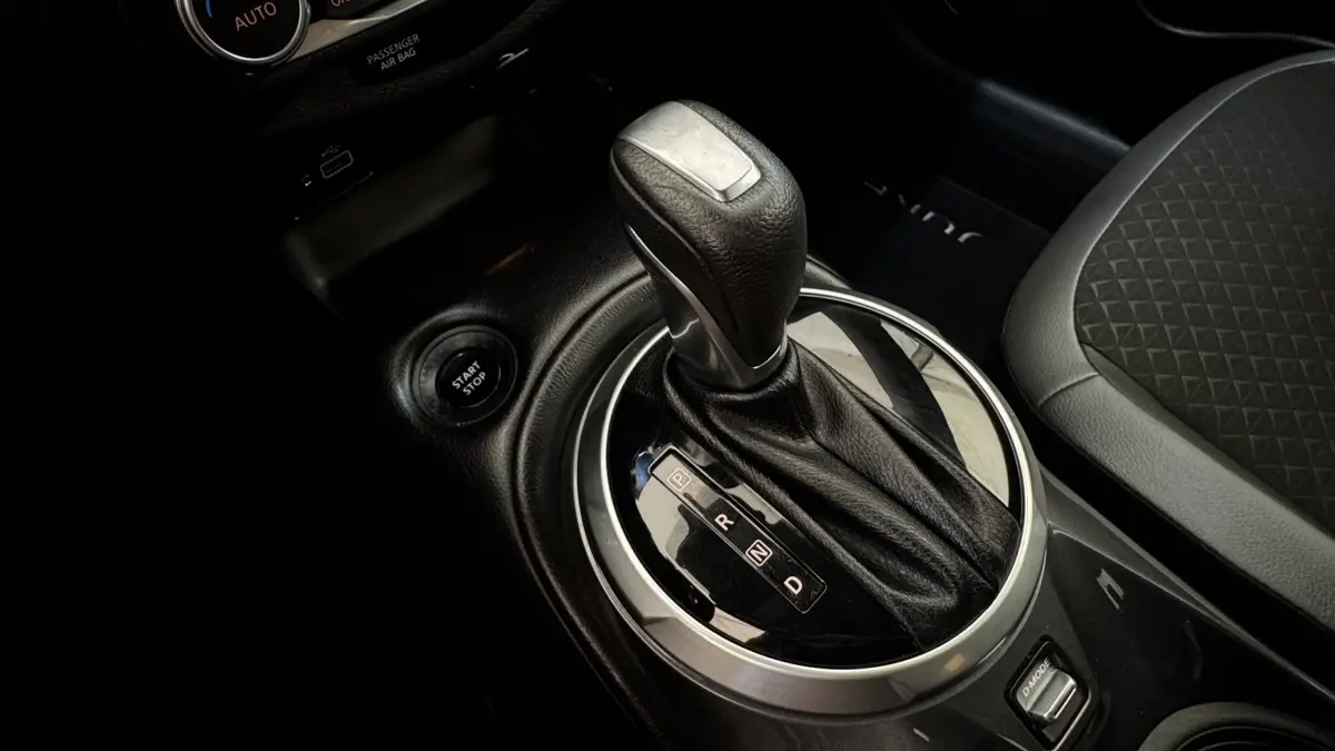Gros plan sur la commande de boîte automatique et bouton start/stop du Nissan Juke Hybrid 2023, intérieur noir.