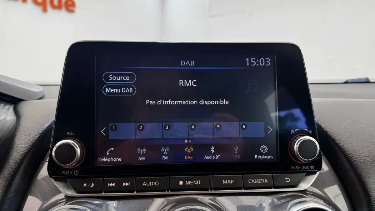 Écran tactile central du Nissan Juke Hybrid 143 Business+ 2023 affichant la radio DAB, vue intérieure frontale.