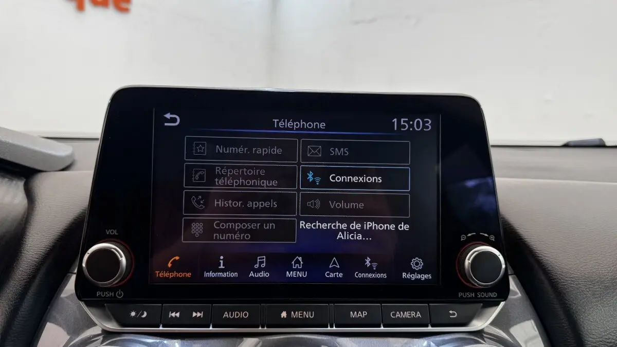 Écran tactile central du tableau de bord du Nissan Juke Hybrid 143 Business+ gris foncé, affichant le menu téléphone.