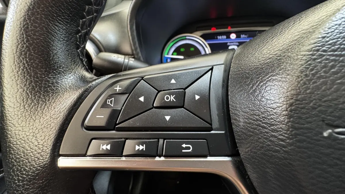 Gros plan sur les commandes multifonctions du volant cuir noir du Nissan Juke Hybrid 143 Business+ 2023.