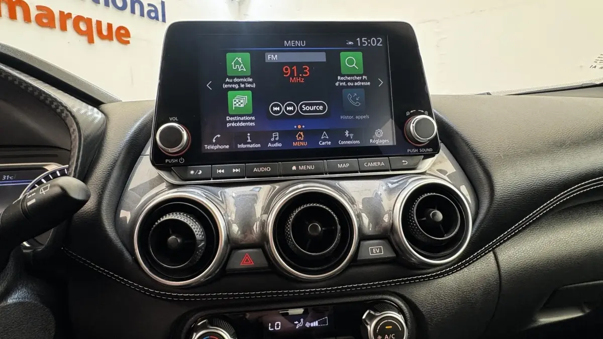 Tableau de bord du Nissan Juke Hybrid 143 Business+ 2023, avec écran tactile central et aérateurs ronds chromés.