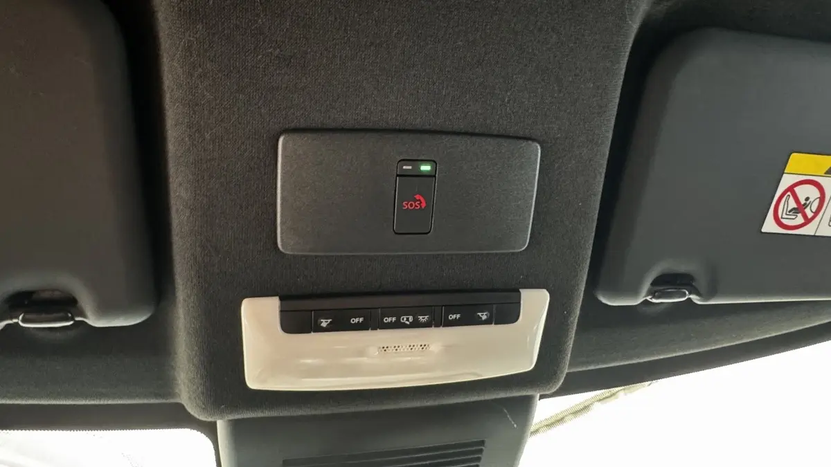 Vue intérieure du plafond du Nissan Juke Hybrid 143 Business+ 2023, montrant le bouton SOS et commandes d'éclairage.