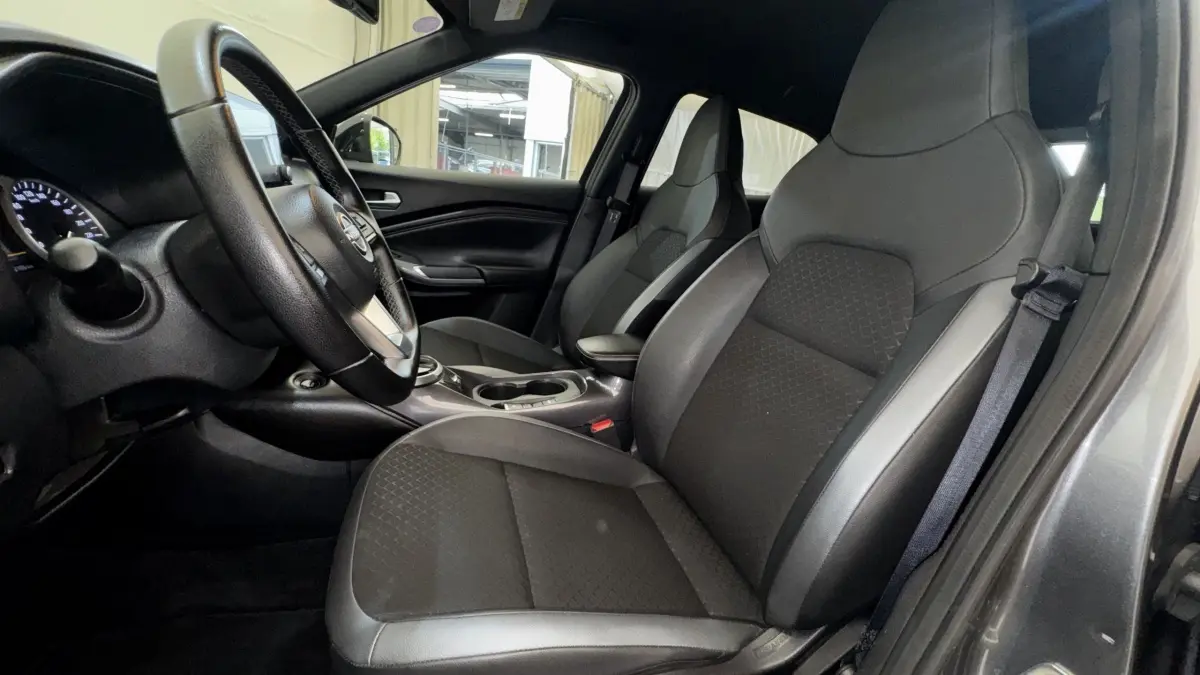 Intérieur Nissan Juke Hybrid gris foncé, vue côté conducteur, sièges avant en cuir et tissu, volant multifonctions.