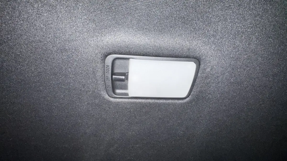 Plafonnier intérieur avec interrupteur de commande, éclairage blanc sur fond de tissu gris foncé.