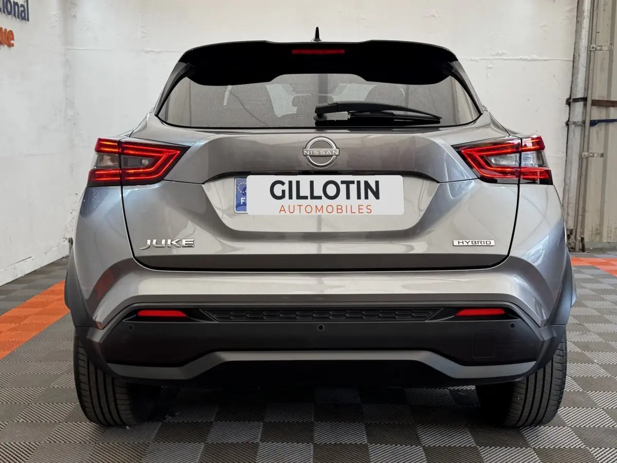 Vue arrière du Nissan Juke Hybrid gris foncé avec feux LED distinctifs et logo Hybrid visible sur le coffre.