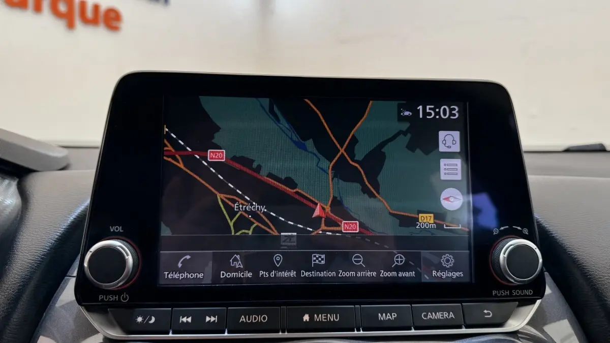 Écran tactile central du Nissan Juke Hybrid 2023 affichant la navigation avec carte et options de menu.