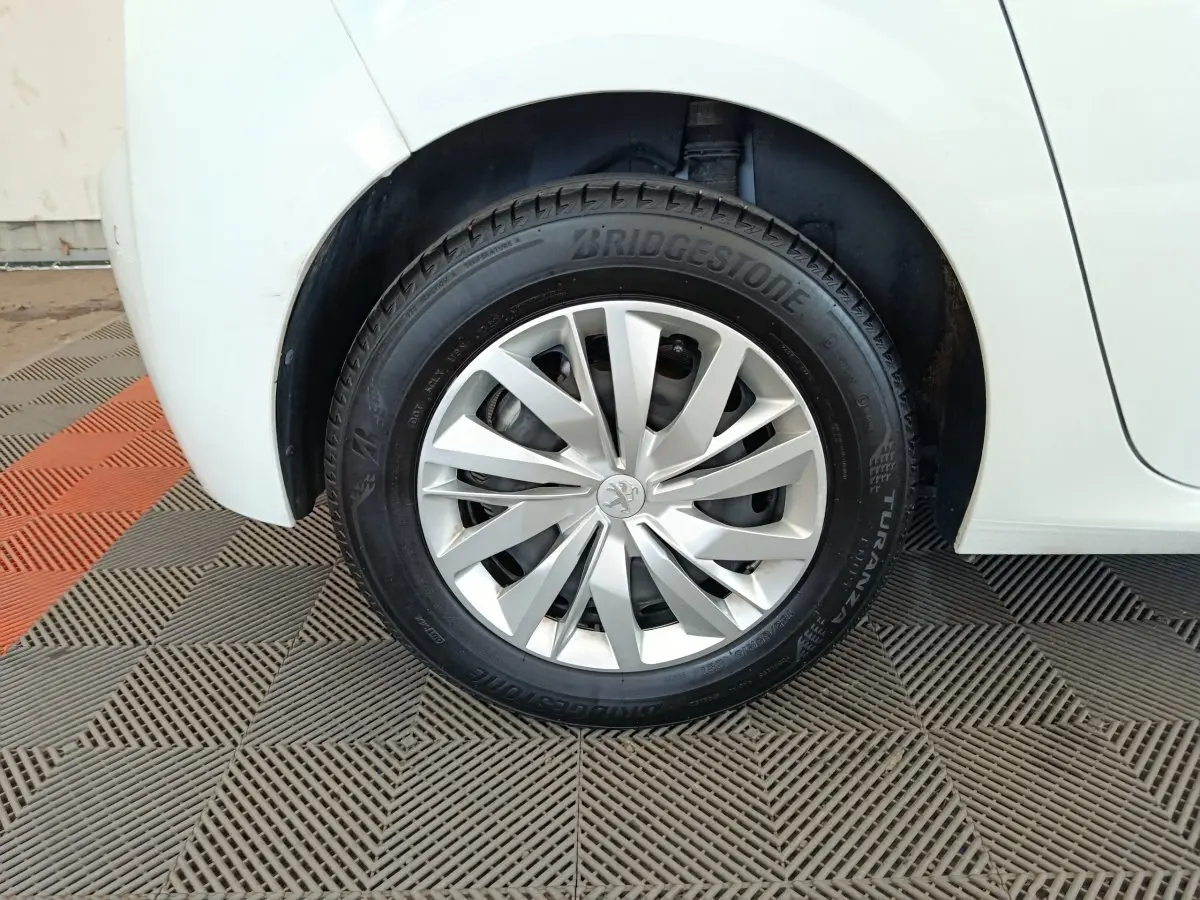 Gros plan sur la roue arrière droite blanche d'une Peugeot 208 1.5 BlueHDi avec jante argentée et pneu Bridgestone.