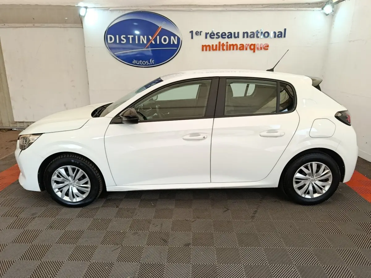 Peugeot 208 blanche vue de profil côté gauche dans un showroom avec jantes alliage et rétroviseurs noirs.