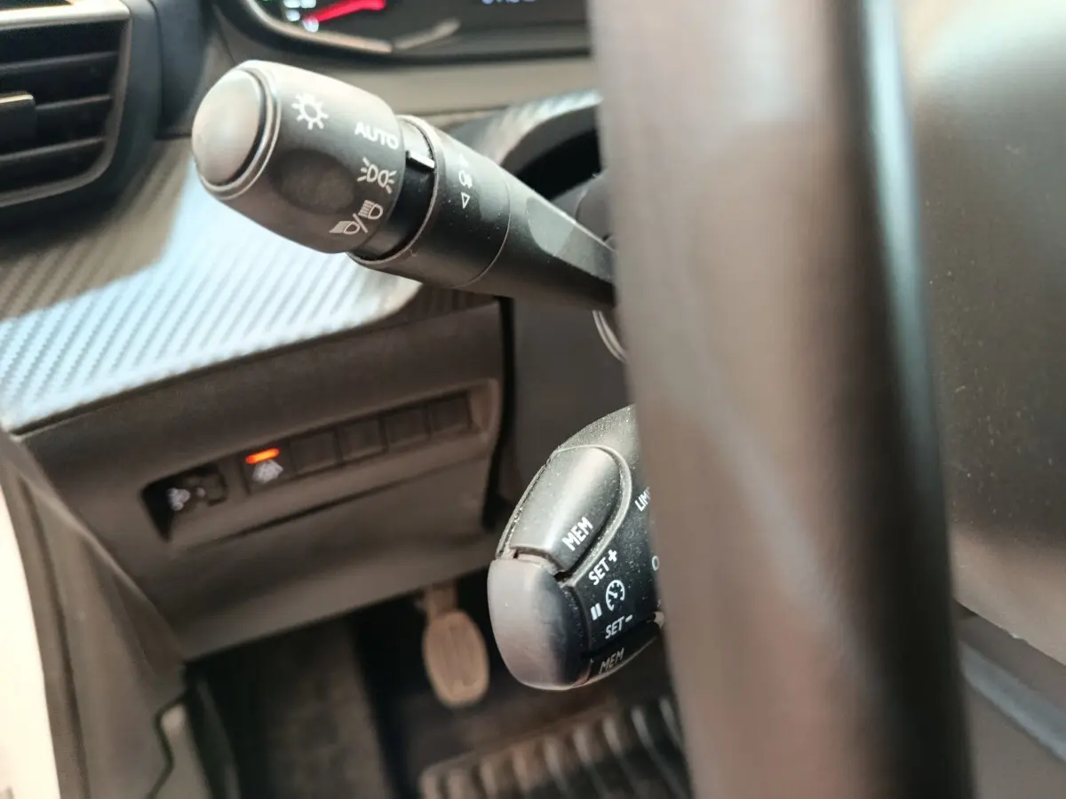 Gros plan sur le volant cuir et les commandes multifonctions de la Peugeot 208 1.5 BlueHDi 100 S&S Premium 2023.