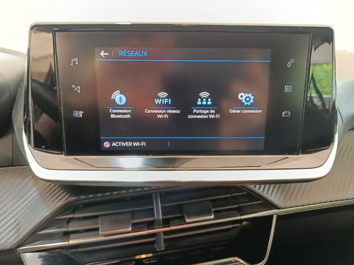 Écran tactile central de la Peugeot 208 1.5 BlueHDi 100 S&S Premium 2023 affichant les options de connexion Wi-Fi et Bluetooth.