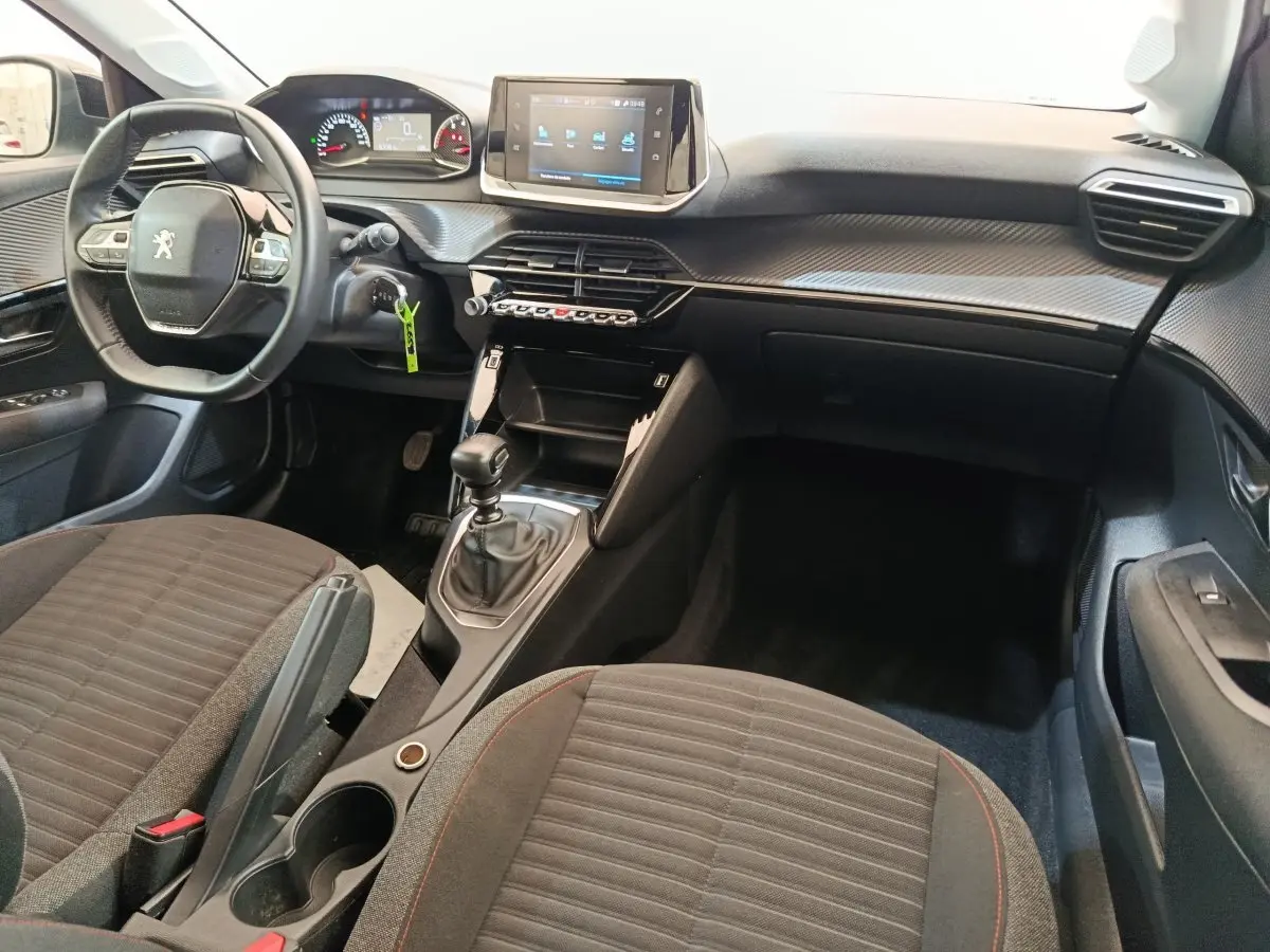 Intérieur de la Peugeot 208 1.5 BlueHDi 2023, vue de face côté conducteur, volant cuir et écran tactile central.