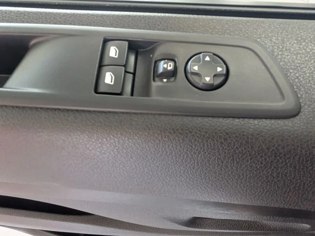 Gros plan sur les commandes de réglage des vitres et des rétroviseurs côté conducteur du Fiat Scudo Fourgon blanc 2025.