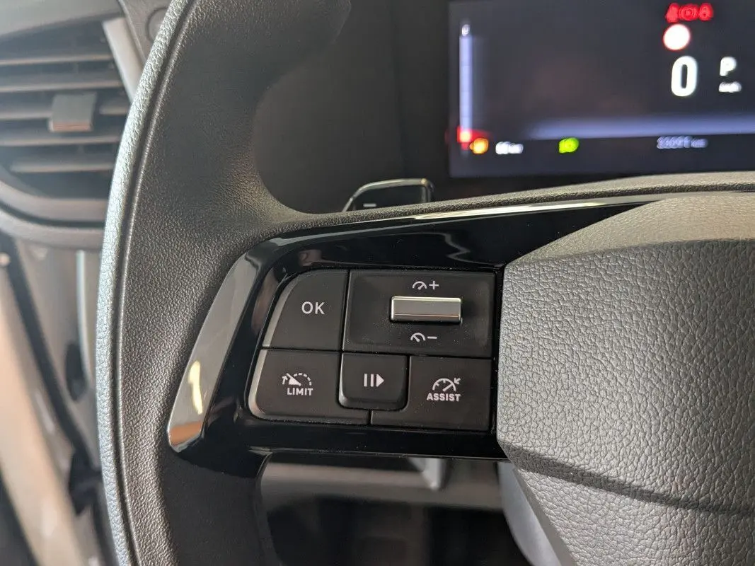 Gros plan sur les commandes au volant du FIAT Scudo Fourgon blanc, avec écran digital en arrière-plan.