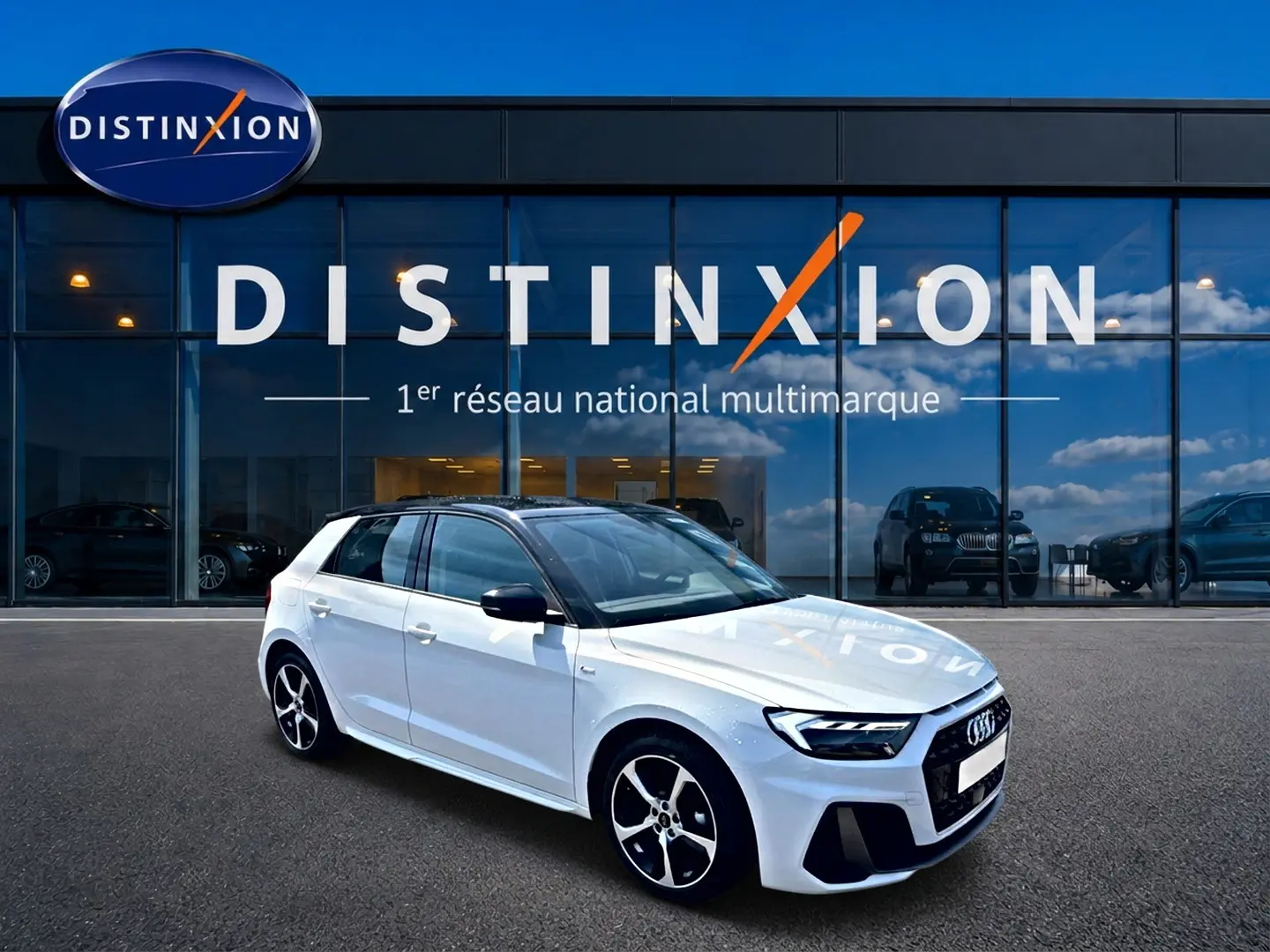 Audi A1 Sportback blanc et noir en 3/4 avant droit devant une vitrine avec logo Distinxion.
