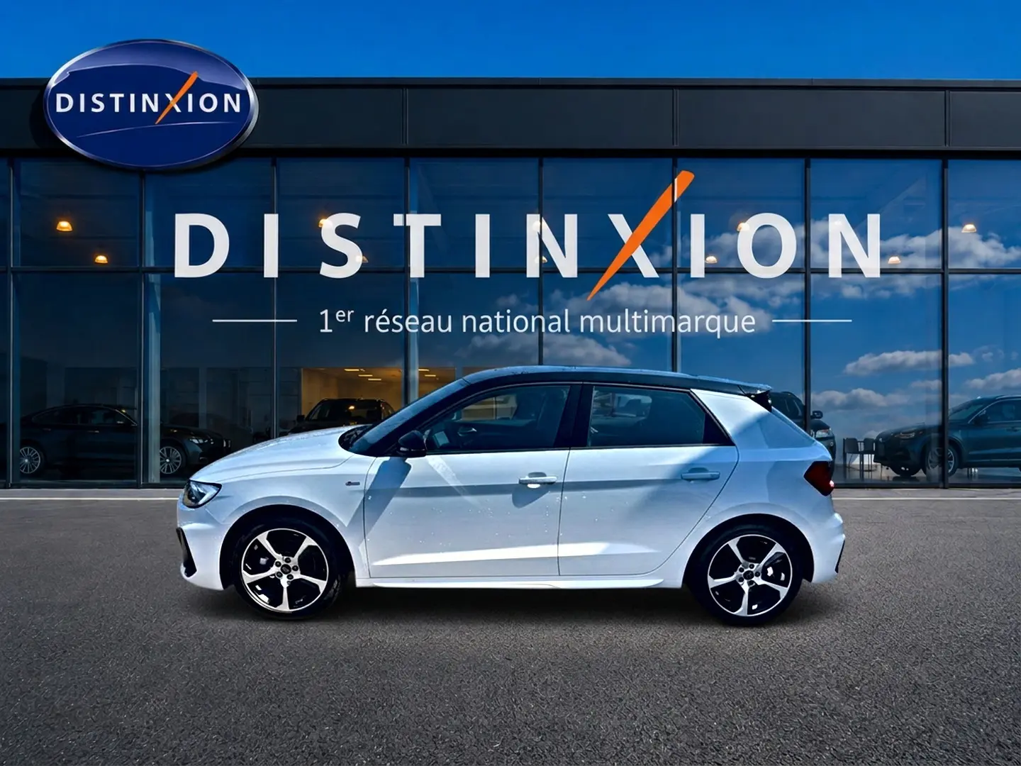 Audi A1 Sportback blanc et noir vue de profil côté gauche devant une vitrine avec logo Distinxion.