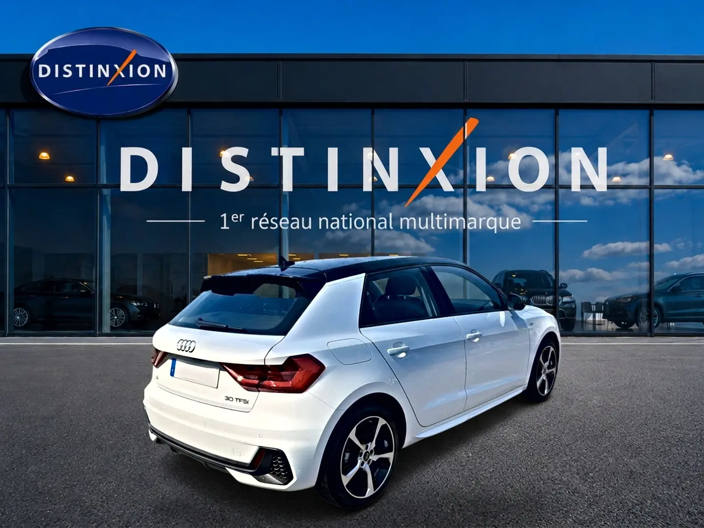 Audi A1 Sportback blanc et noir vue 3/4 arrière droit avec jantes alu et toit contrasté noir devant vitrine Distinxion.