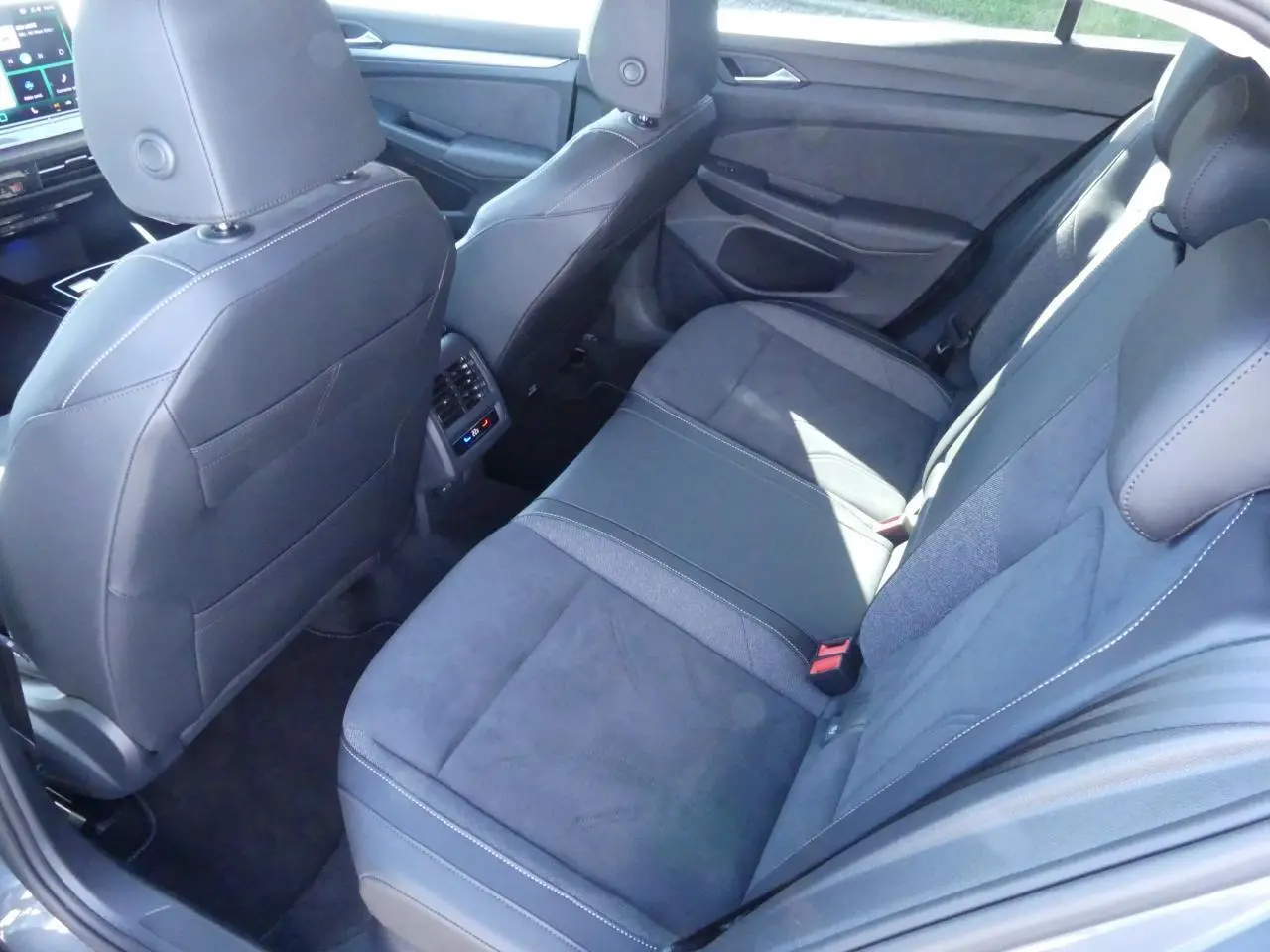 Vue intérieure arrière côté droit de la Volkswagen Golf Style 2024 avec sièges microfleece gris et finitions modernes