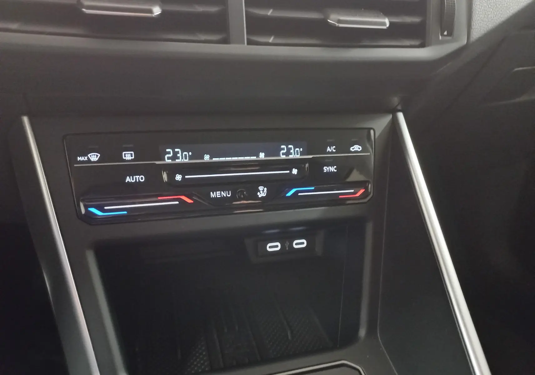 Panneau de commande de la climatisation bi-zone tactile du Volkswagen Taigo 2025, affichage digital avec réglages température à 23°C.