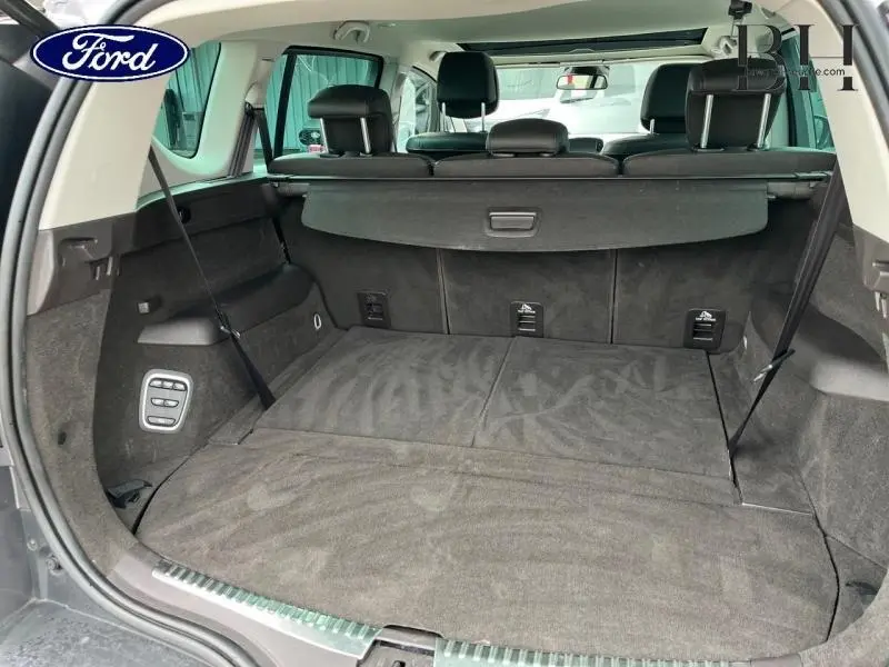 Vue arrière du coffre spacieux gris foncé du Renault Espace 2017 avec sièges arrière rabattus et toit ouvrant panoramique visible.