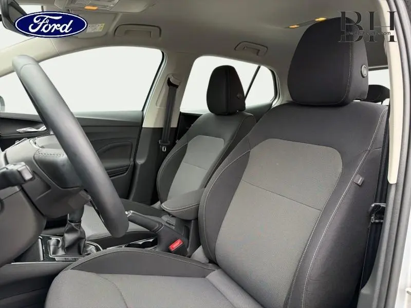 Vue intérieure côté conducteur montrant les sièges en tissu gris et la console centrale d'une Skoda Fabia 2023.