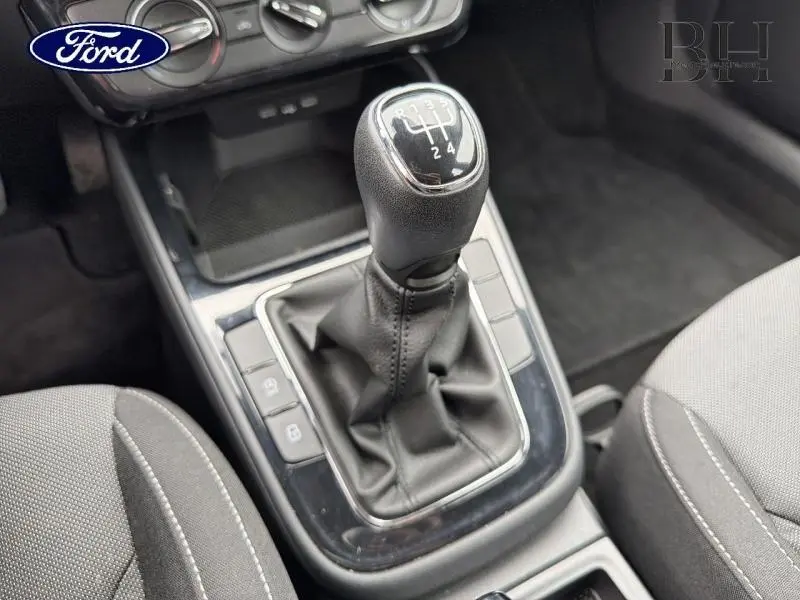 Gros plan sur le levier de vitesses manuel en cuir dans l'habitacle gris d'une Skoda Fabia 2023.
