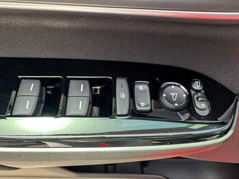 Gros plan sur les commandes de lève-vitres et réglages des rétroviseurs côté conducteur du Honda CR-V rouge Rallye 2020.