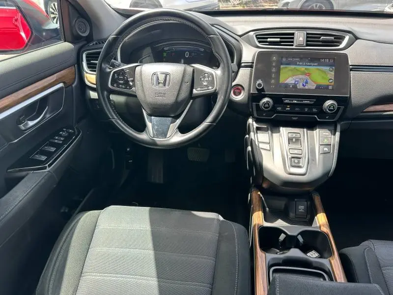 Intérieur Honda CR-V 2020 vu de face, volant cuir multifonction, écran tactile GPS et inserts bois sur console centrale.