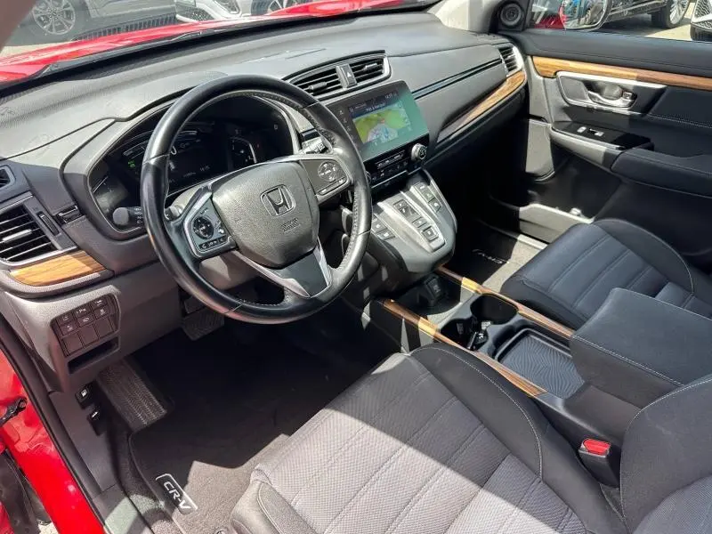 Vue intérieure côté conducteur du Honda CR-V rouge Rallye 2020, avec tableau de bord bois et écran tactile central.