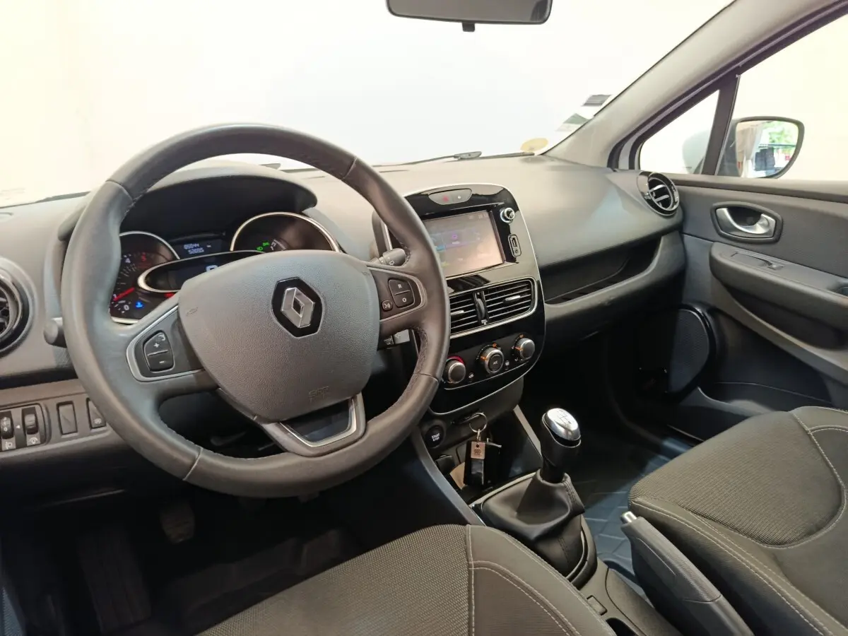 Intérieur avant droit de Renault Clio Business dCi 75 2018, volant cuir multifonctions et écran tactile central visible.