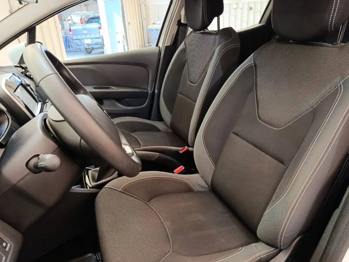 Vue intérieure côté conducteur de la Renault Clio Business 2018, sièges tissu noirs et volant cuir multifonctions.