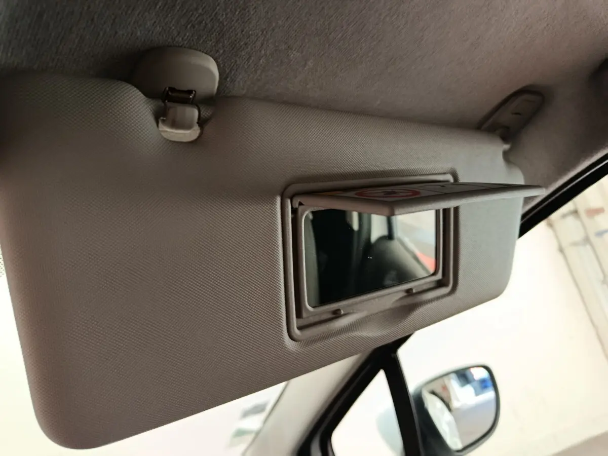 Détail de pare-soleil avec miroir intégré côté conducteur dans l’habitacle d’une Renault Clio blanche de 2018.
