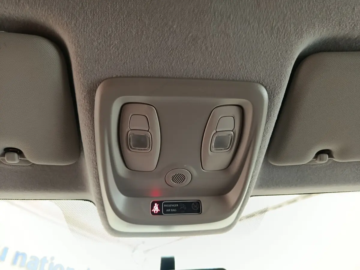 Plafonnier intérieur avec lampes de lecture et témoin airbag passager allumé dans Renault Clio Business blanc.